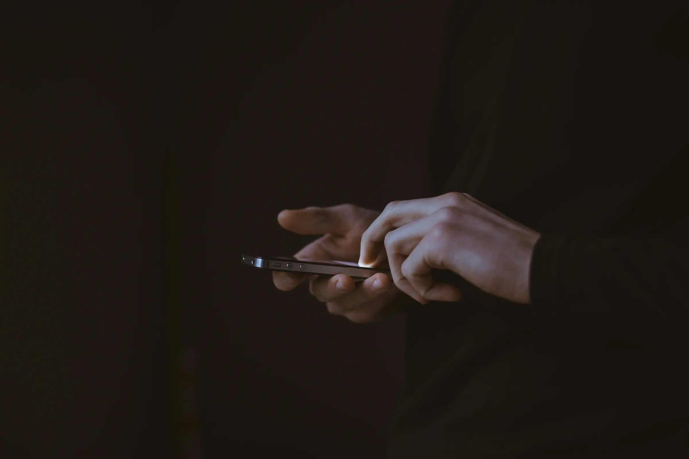 A mobile phone used in the dark (Photo by Gilles Lambert on Unsplash)