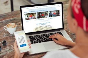 Vrouw bekijkt Wageningen Campus website op haar laptop en mobiele telefoon
